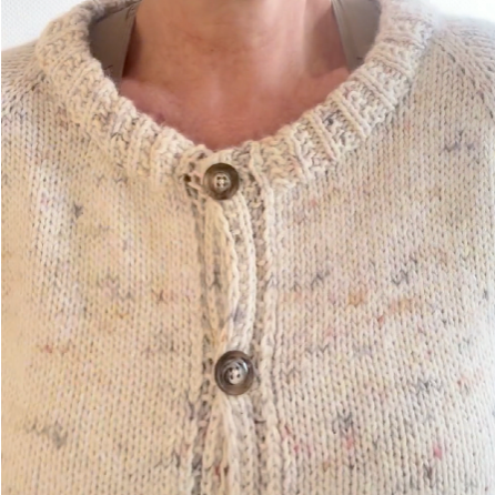 Close-up of the neckline and button band of the Key Piece Cardigan in white.